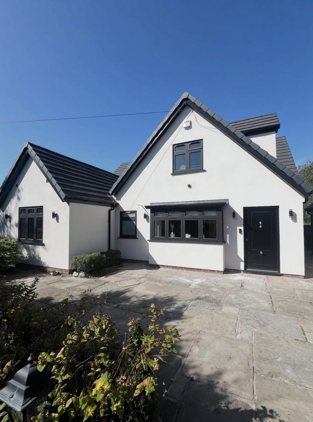 House with steep white rendered gables and dark windows