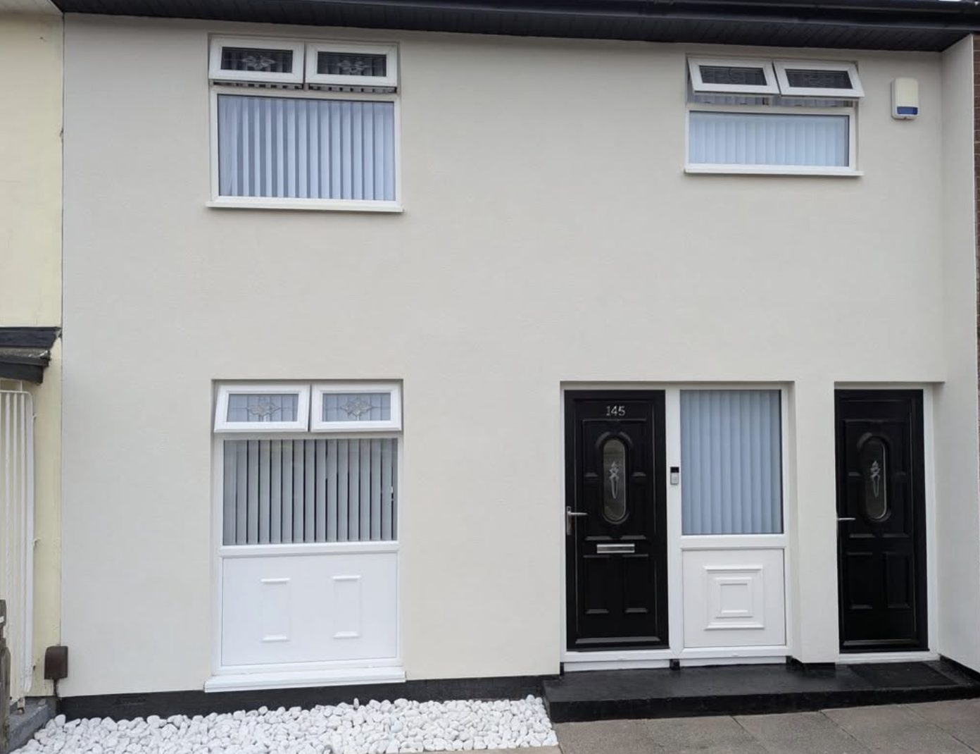 Two terraced house fronts in matching smooth cream render